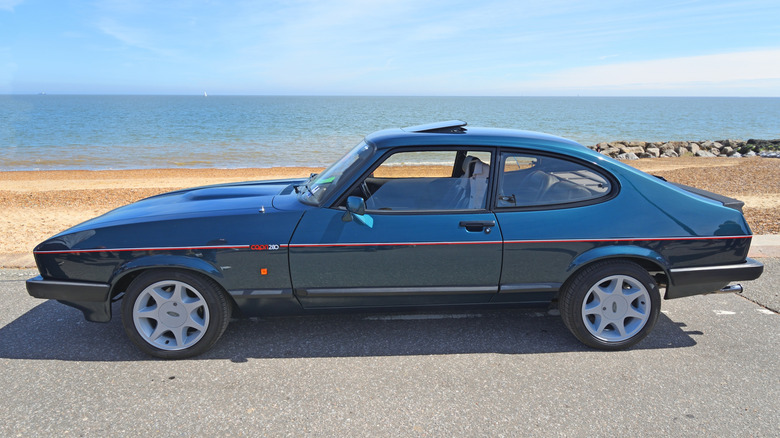 A side shot of a Ford Capri 280 Brooklands parked near a beach