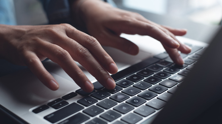 Hands typing on keyboard