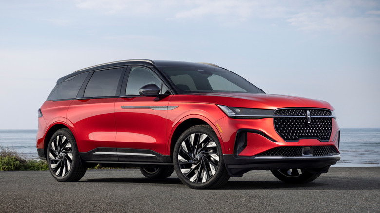 Red 2024 Lincoln Nautilus SUV seen from right front against an ocean backdrop
