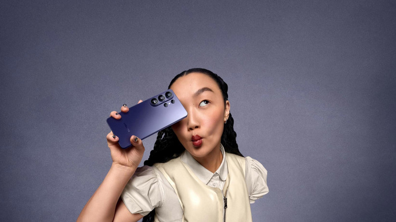Samsung Galaxy S26 Ultra held by a girl over a gradient background