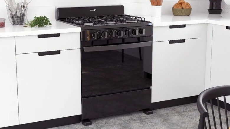 A black Acros burner stove in a white and gray kitchen