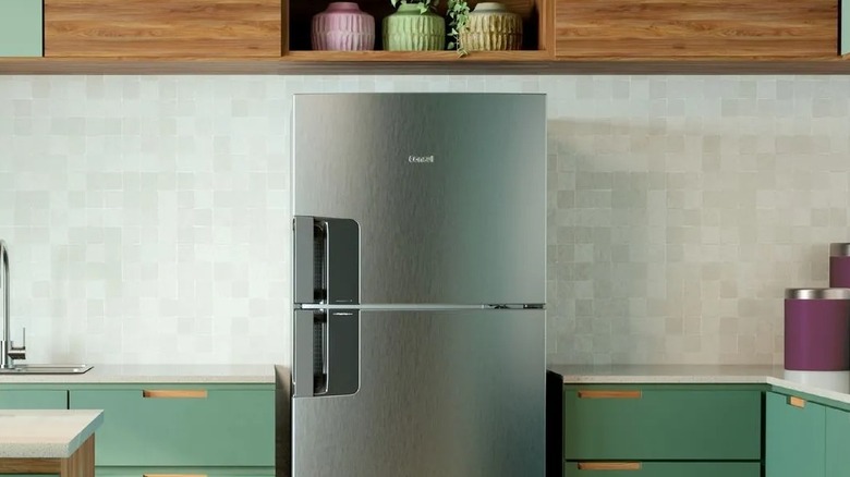A stainless steel Consul Frost Free Refrigerator in a teal and wood-toned kitchen