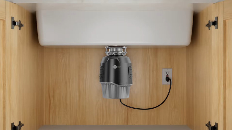 An InSinkErator garbage disposal installed under a kitchen sink