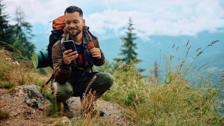 A man on in his phone outdoors