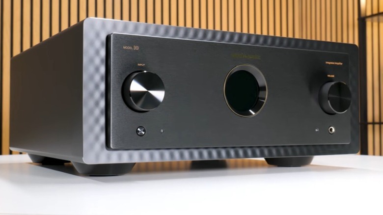 Black Marantz Model 10 amplifier on a white table with a wooden wall in the background.