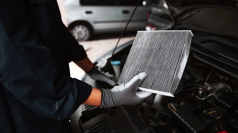 A person changing an engine air filter