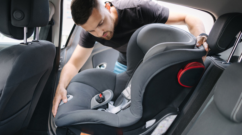 Man removes car seat from car