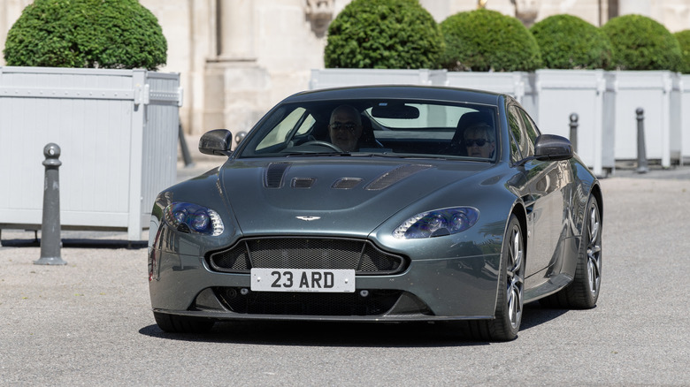 Dark green Aston Martin Vantage S driving.