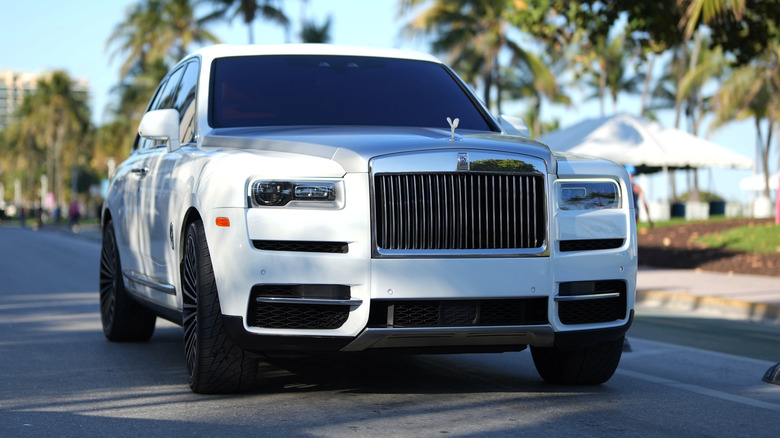 Close-up view of a white Rolls-Royce Ghost driving down a street.
