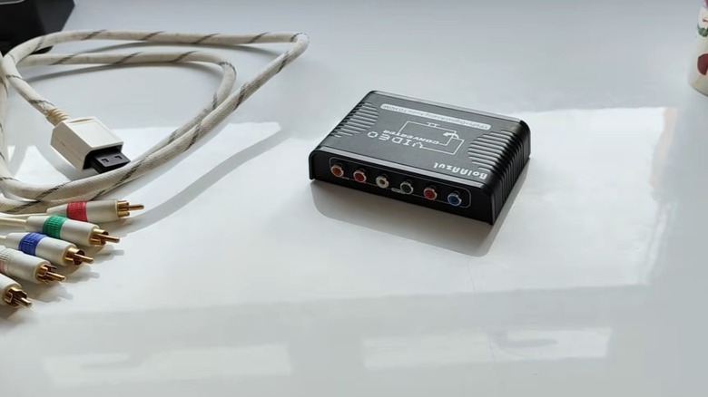 An HDMI converter sitting on a table with old cables nearby