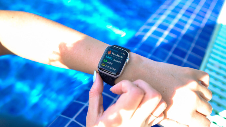 The MySwimPro app being displayed on an Apple Watch worn on the left arm.