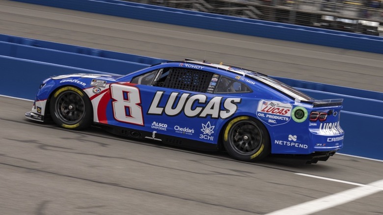 A blue stock car driving on a track