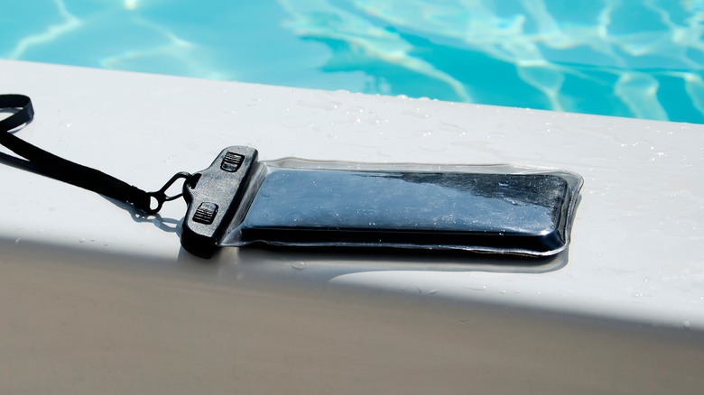 Android telefon egy vízálló tasakban egy medence közelében