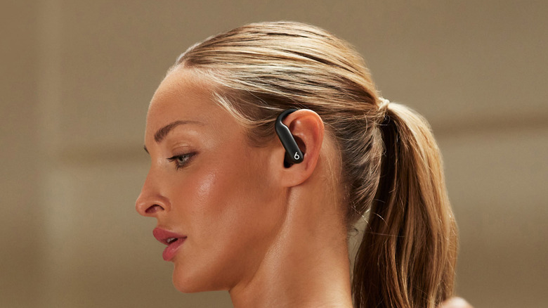 A person looking down while wearing the Beats Powerbeats Pro 2 earbuds