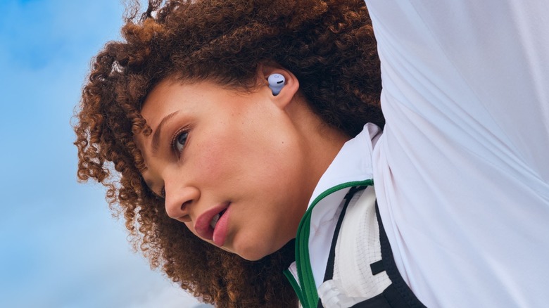 A person looking to the side and wearing the Google Pixel Buds 2a earbuds