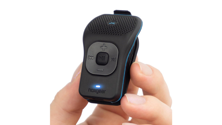 A person holding a Noxgear mini speaker in their hand