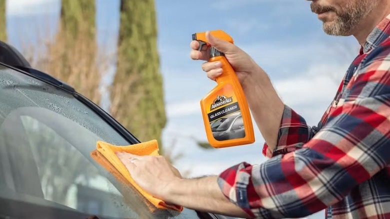 Person cleaning car windshield with Armor All