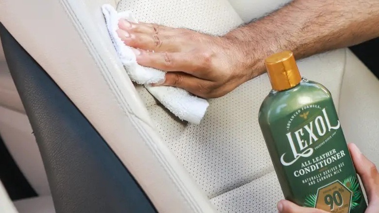 Close up of a person cleaning car upholstery with Lexol