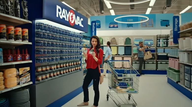 Person looking at Rayovac batteries on display on a store shelf.