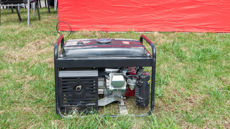 generator on grass next to red tent