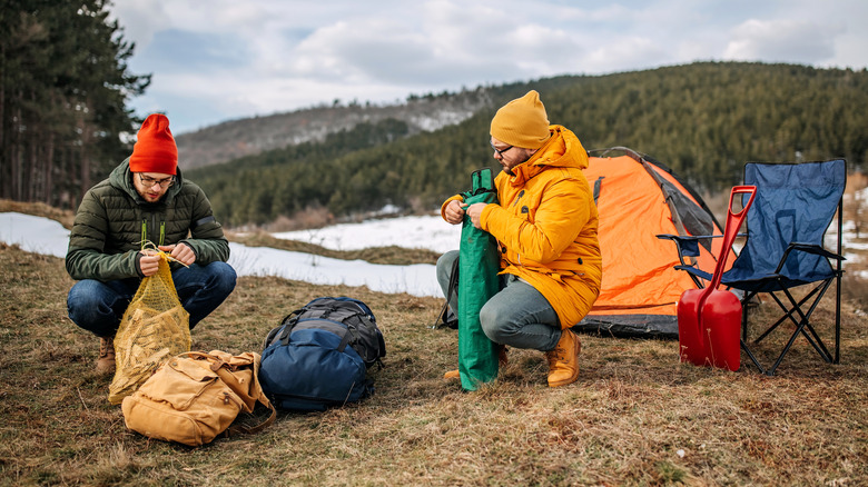 two men setting up a campsite