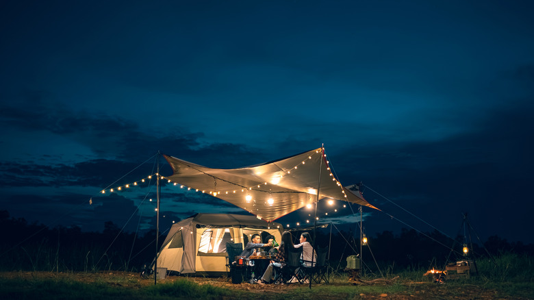 four people under canvas with string lights
