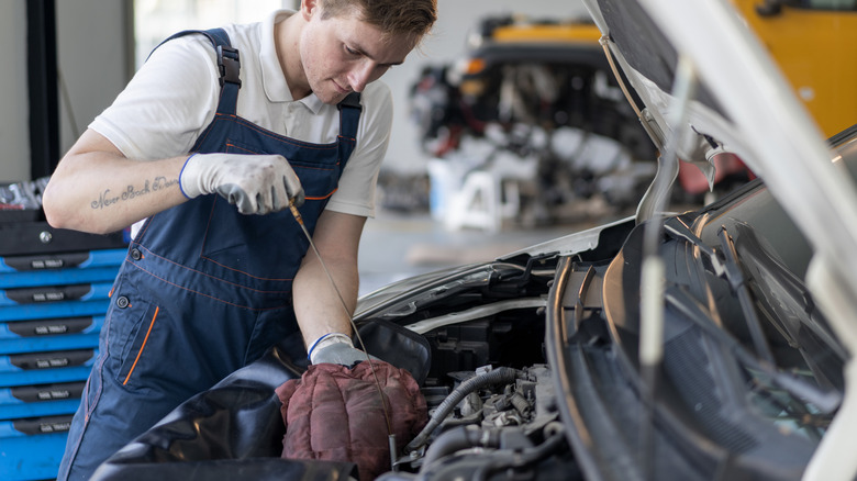 Mechanic checking an oil dipstick