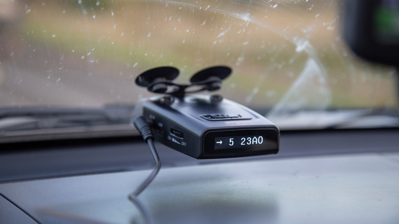 A radar detector installed on a car dashboard