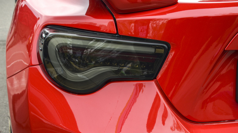Tinted aftermarket taillight on a red sports car