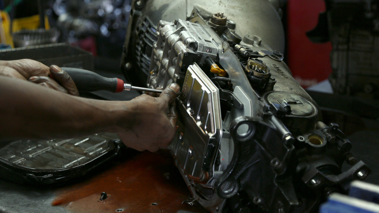 Mechanic taking a part a car's transmission