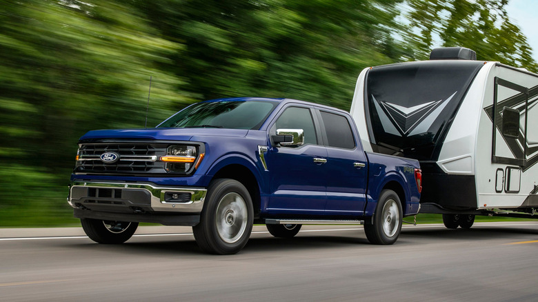 A side on shot of a 2026 Ford F-150 towing a trailer