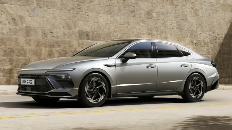 Silver Hyundai Sonata on the road with a stone wall in the background