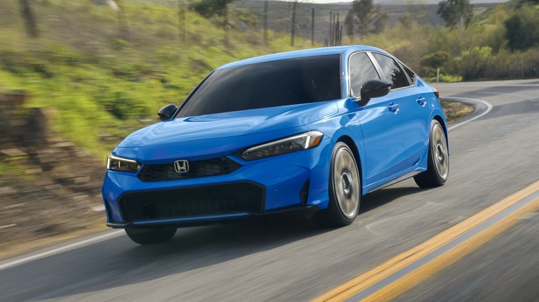 Blue Honda Civic Hatchback driving on a rural road