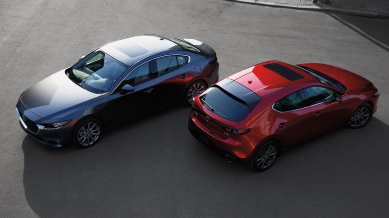 Overhead view of black Mazda3 Sedan and red Mazda3 Hatchback parked next to each other