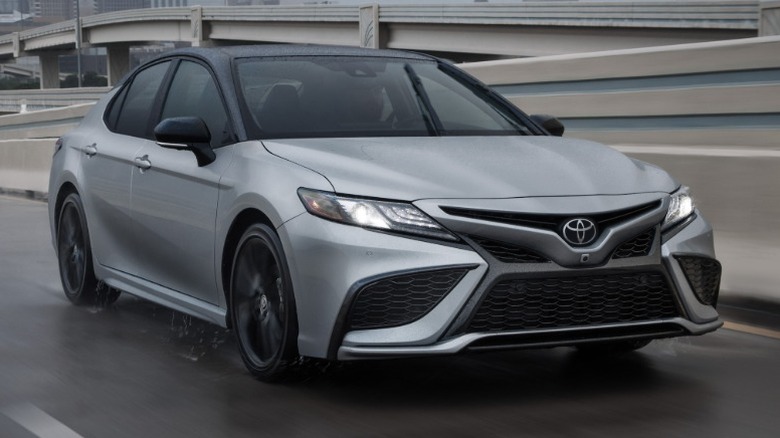 Silver Toyota Camry driving on a highway in the rain