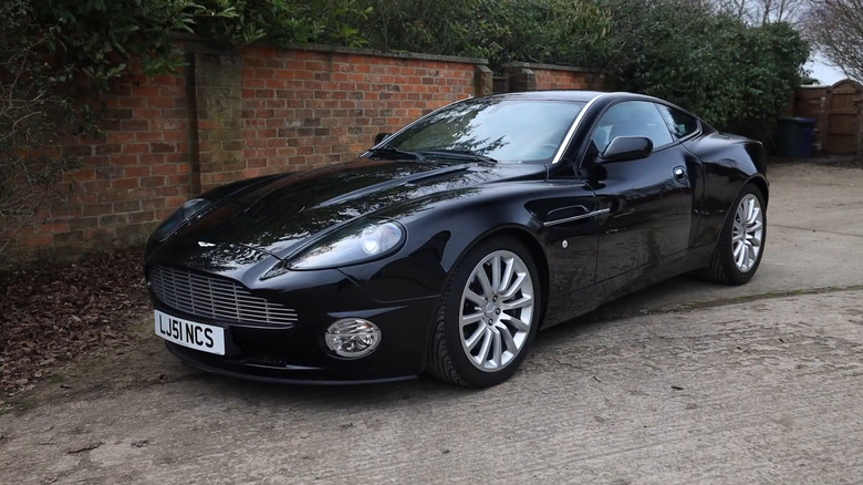 A side on shot of a black 2002 Aston Martin V12 Vanquish