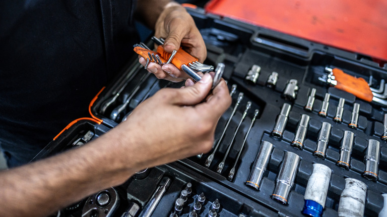 person selecting hex wrenches from a case