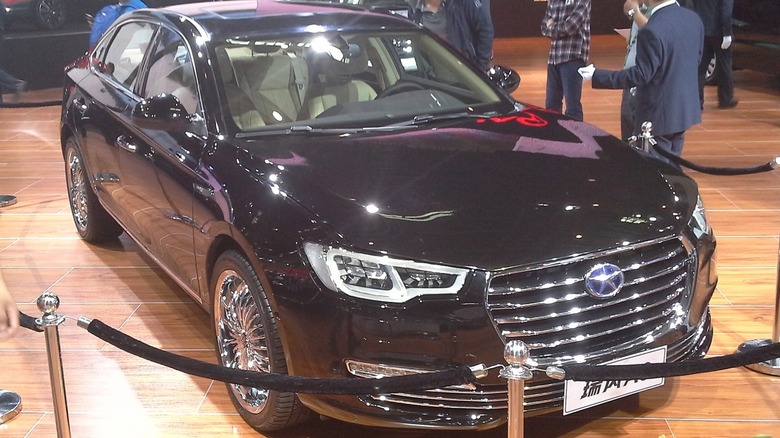 A black JAC Refine A60 behind a barrier at a public showing event