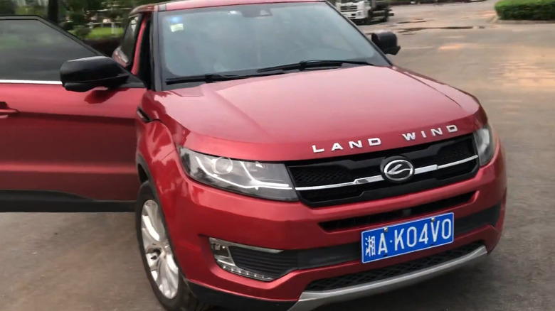 A metallic red Land Wind X7 SUV parked on a private road