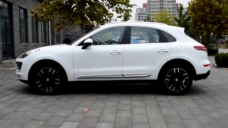 A white Zotye T700/ SR9 parked in front of a building, side view visible