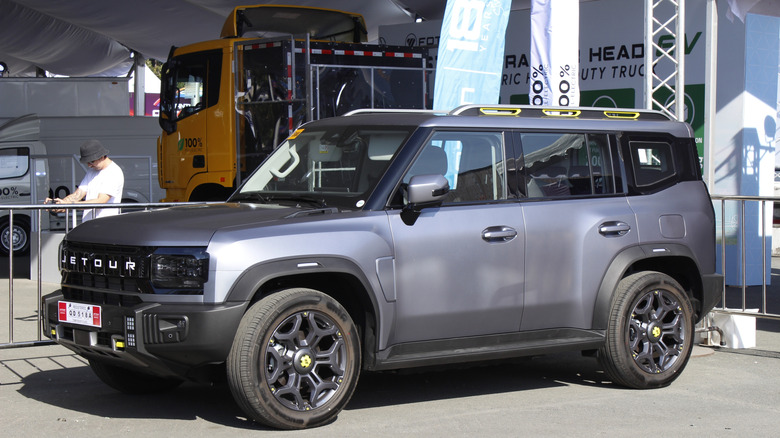 A Jetour Traveler T2, that is unmistakeably a copy of the Land Rover Defender parked at a show.
