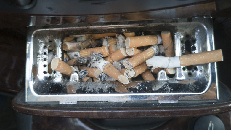 car ashtray full cigarettes