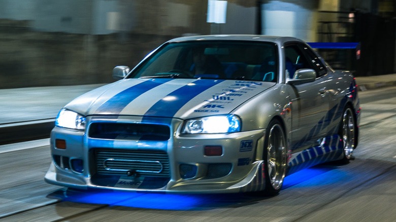 Silver car with blue under glow lighting on road