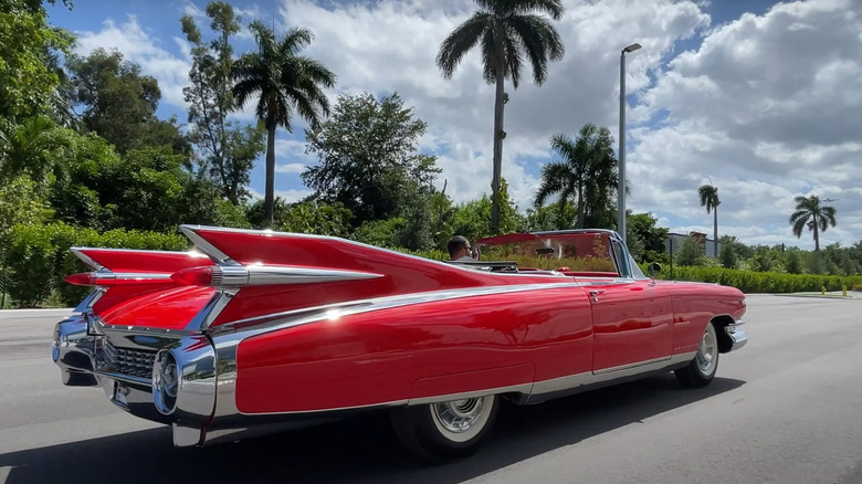 Side view of a 1959 Cadillac Eldorado convertible in metallic green, showcasing its iconic tailfins and dual bullet taillights