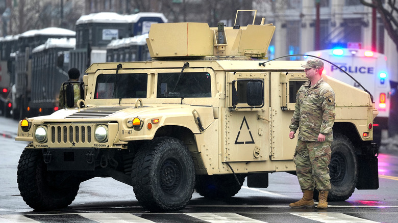 Soldier in front of humvee at intersection