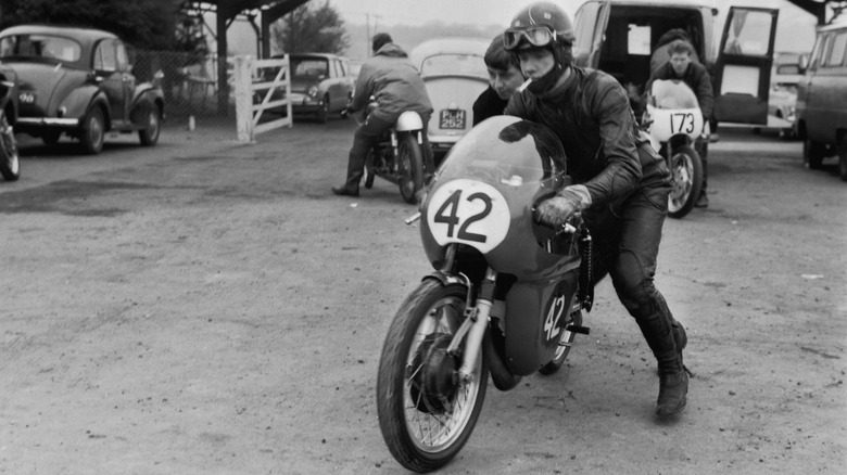 Barry Sheene pushes Bultaco motorcycle