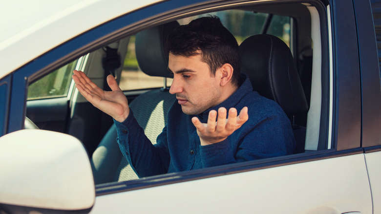 Concerned car owner with hands in the air