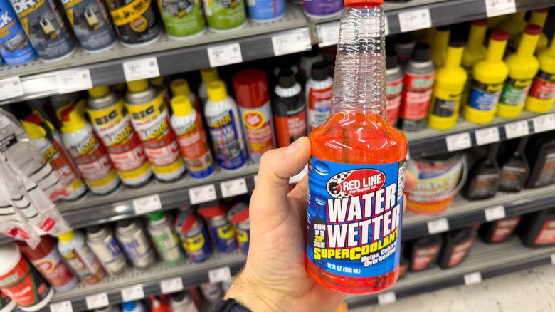 Hand holding a bottle of Water Wetter in auto parts store aisle