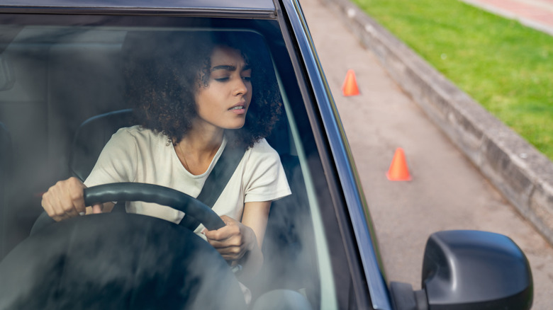 young woman trying to parallel park in driving school