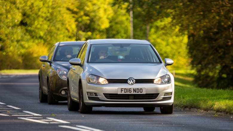 a black car tailgating a silver car